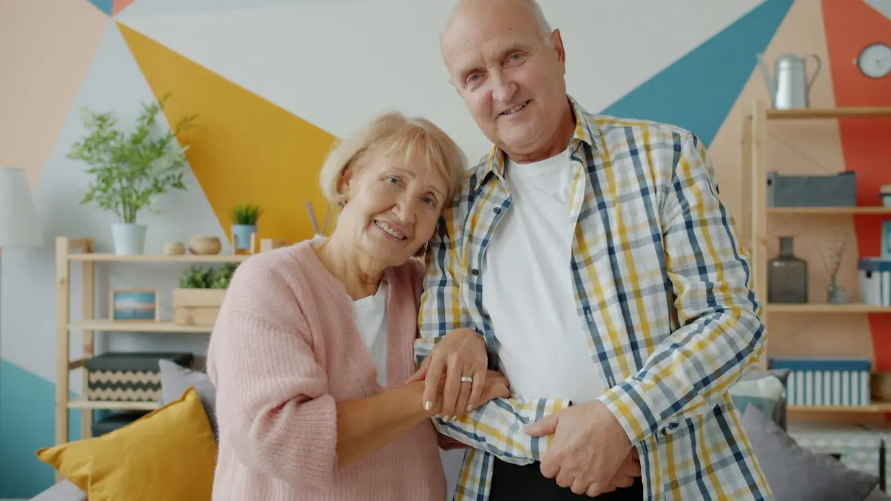 Couple de seniors souriant chez eux